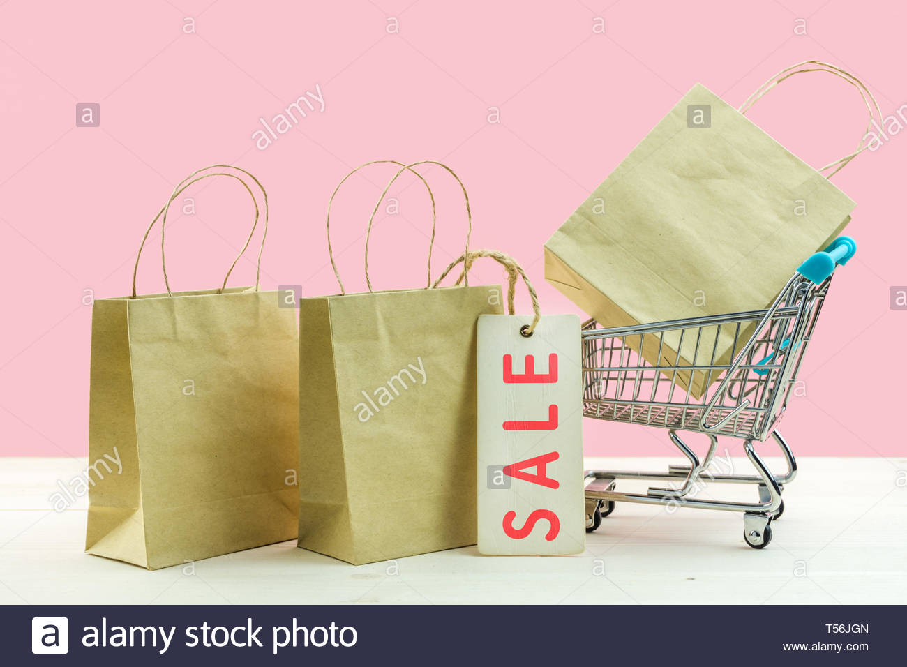 Trolley Cart And Paper Shopping Bags On Pink Background Creative