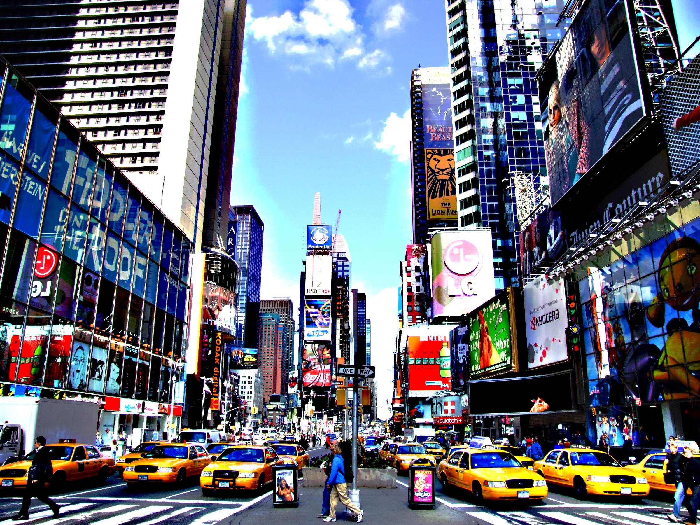 A vibrant photo of Times Square in New York City, showcasing the bright lights, billboards, and yellow taxis that characterize Broadway