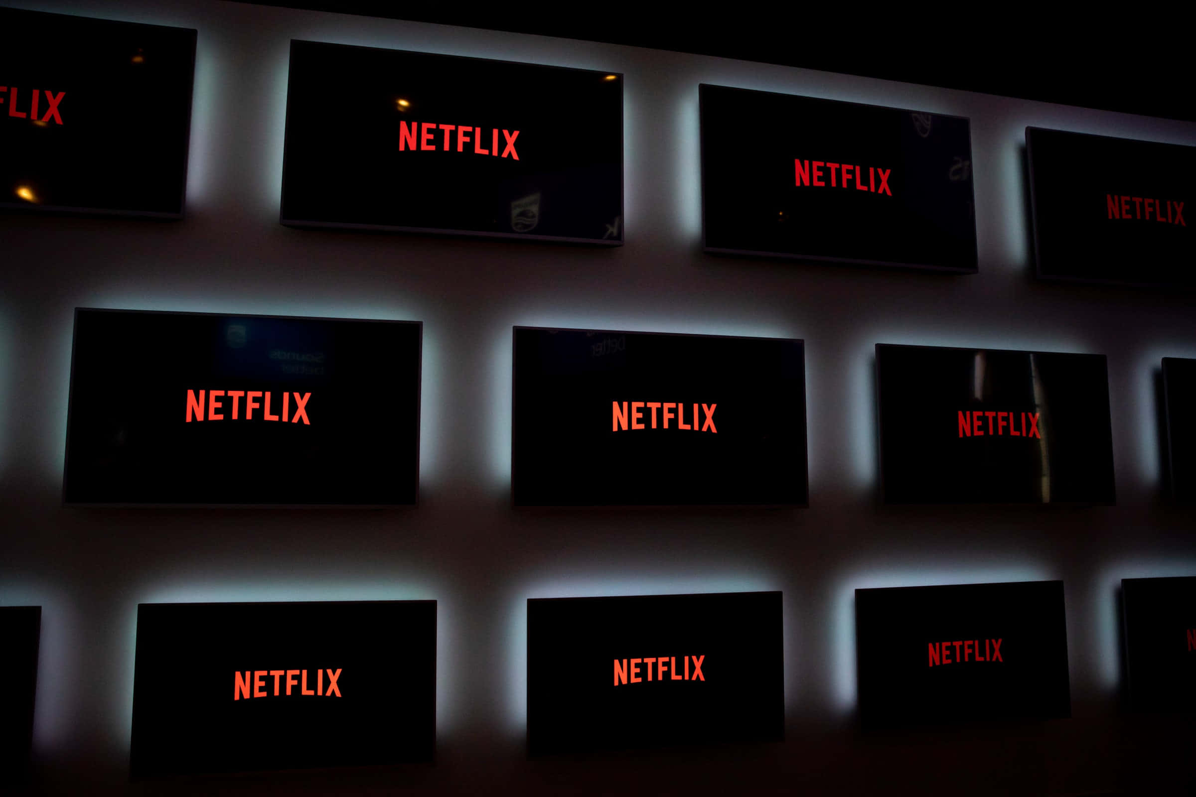 A wall of Netflix logos glowing red in a dark room, perfect for Netflix enthusiasts