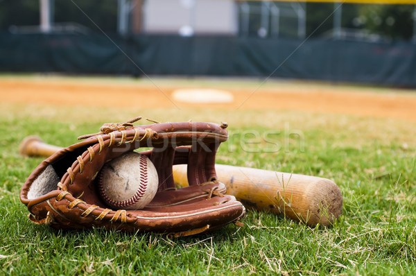 Baseball Glove And Bat On Field With Base Outfield In Background