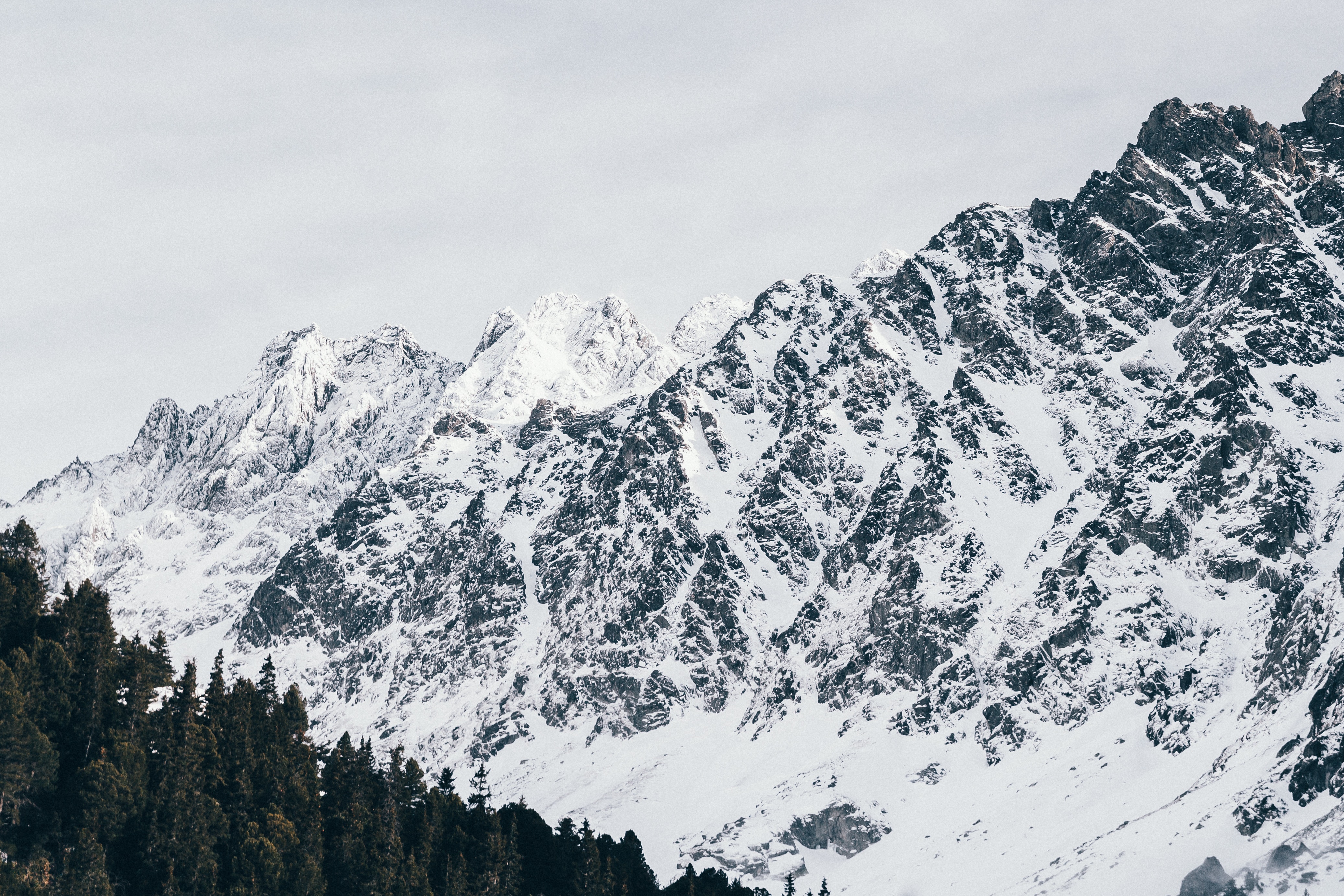 Majestic snow-capped mountain peaks against a cloudy sky