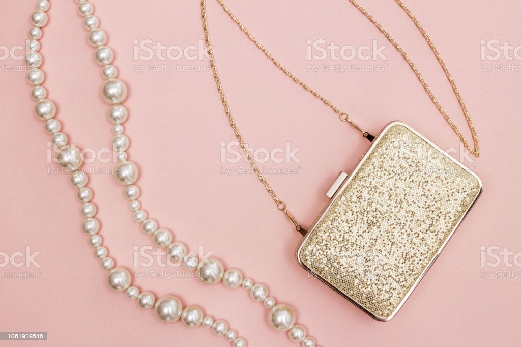Golden Purse And Pearl Necklace On Pink Background Stock Photo
