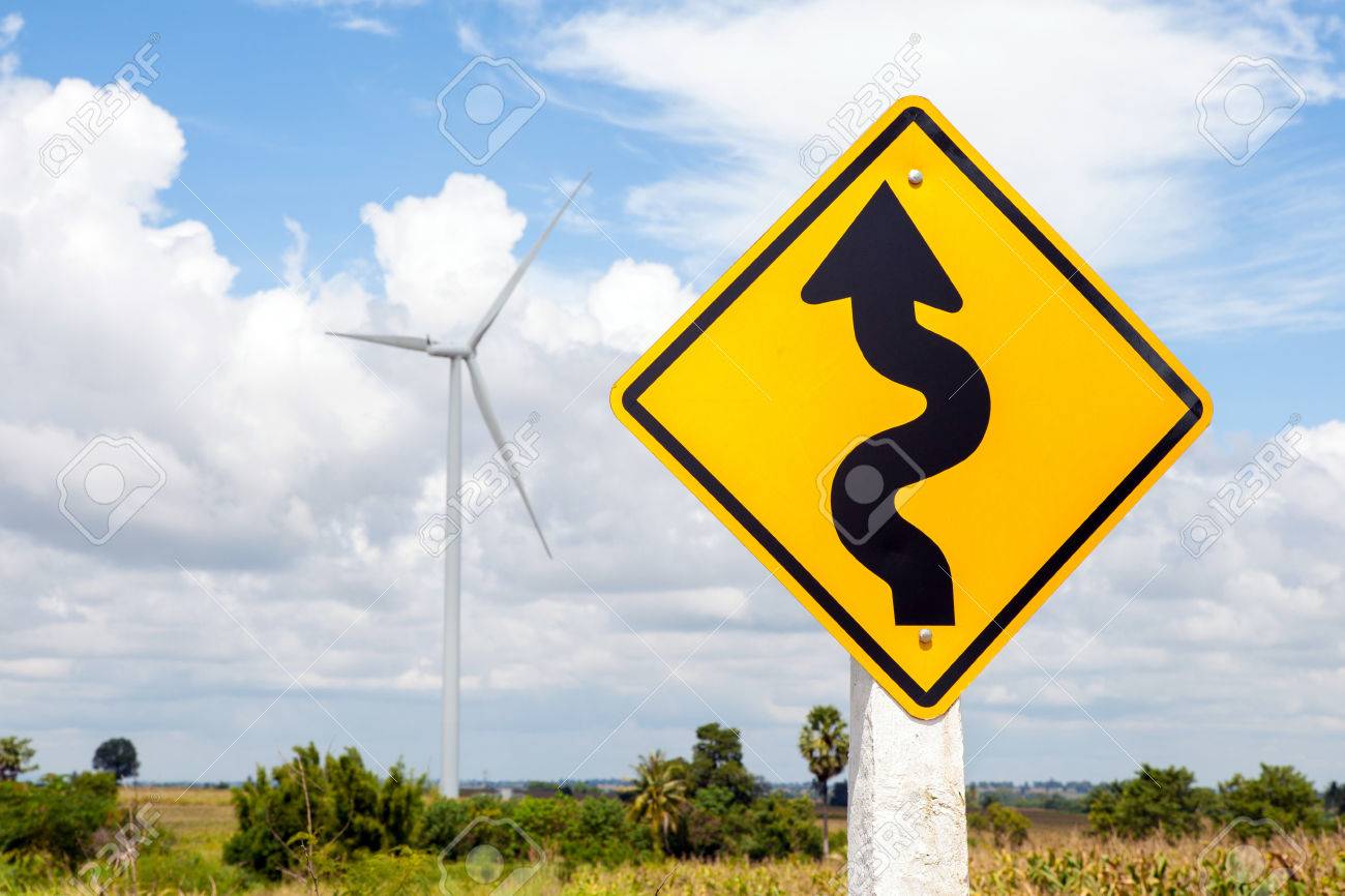 Winding Road Sign And Windmill Background In Wind Farm Korat
