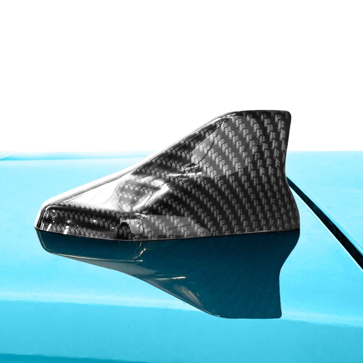 Close-up of a carbon fiber shark fin antenna on a bright blue car