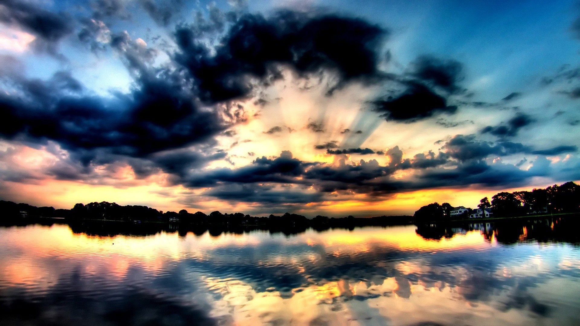 A breathtaking sunset reflected in a calm lake, with dramatic clouds and vibrant colors