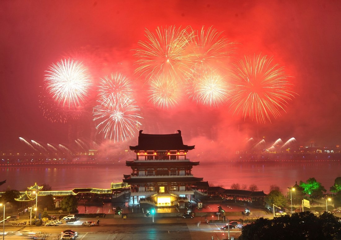 Fireworks light up the night sky over a traditional Chinese building, celebrating New Year 2025