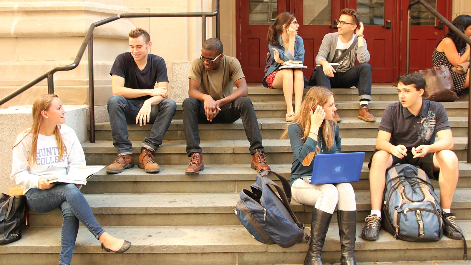 A Group Of Students Sitting On Steps   College Students Sitting On