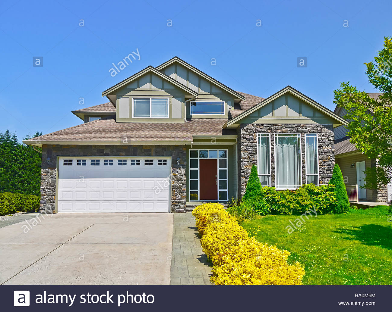 Luxury Family House With Concrete Driveway To The Garage On Blue