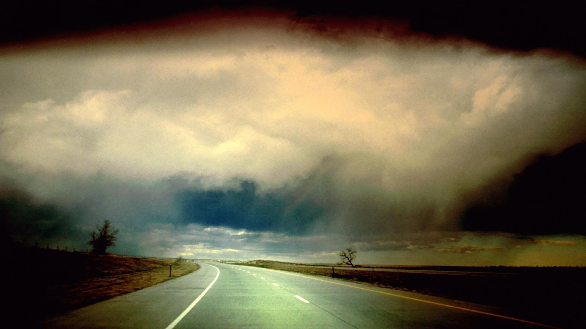 Storm clouds over empty road wallpaper