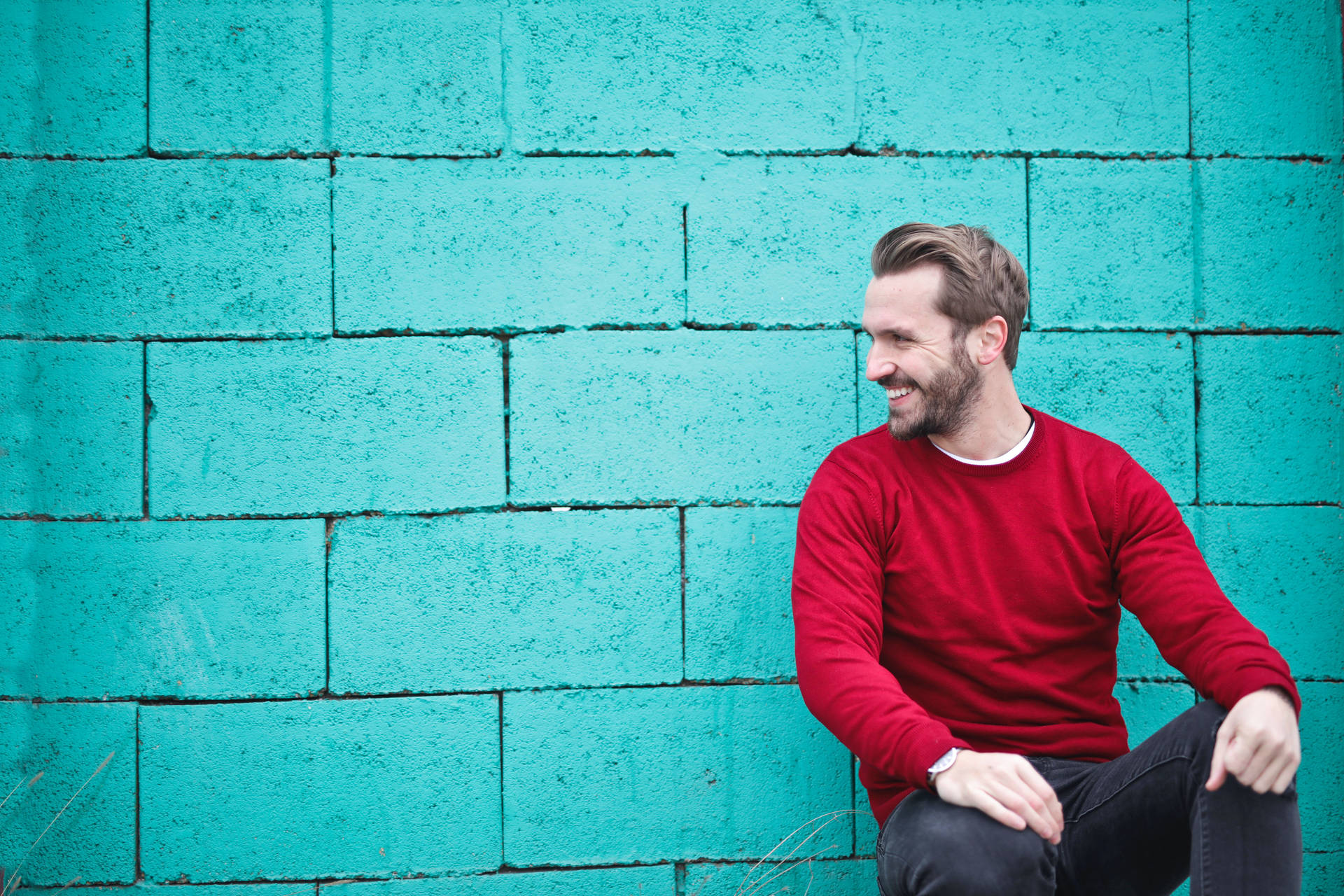 Male Pose Against Blue Brick Wall Wallpaper