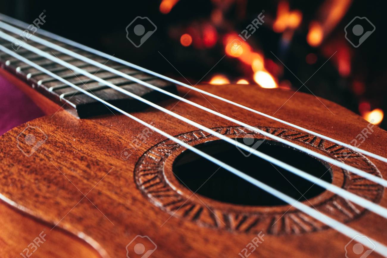 Ukulele Small Guitar Close Up Stings Fireplace On The Background