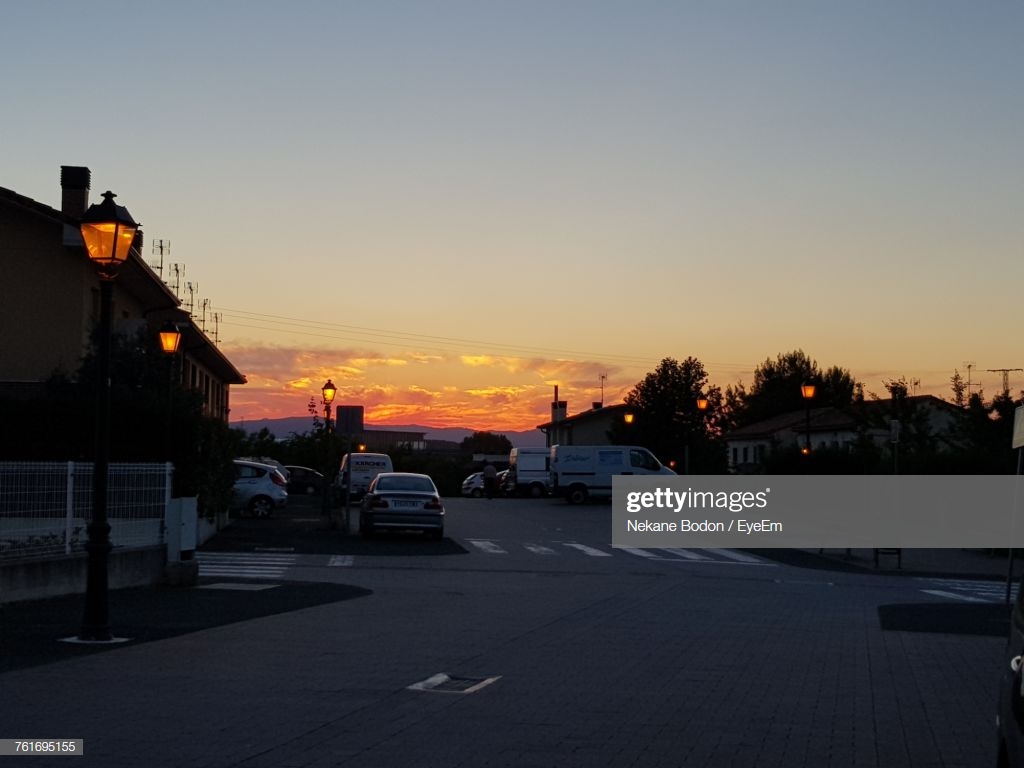 Cars On Street In City Against Sky During Sunset Stock Foto