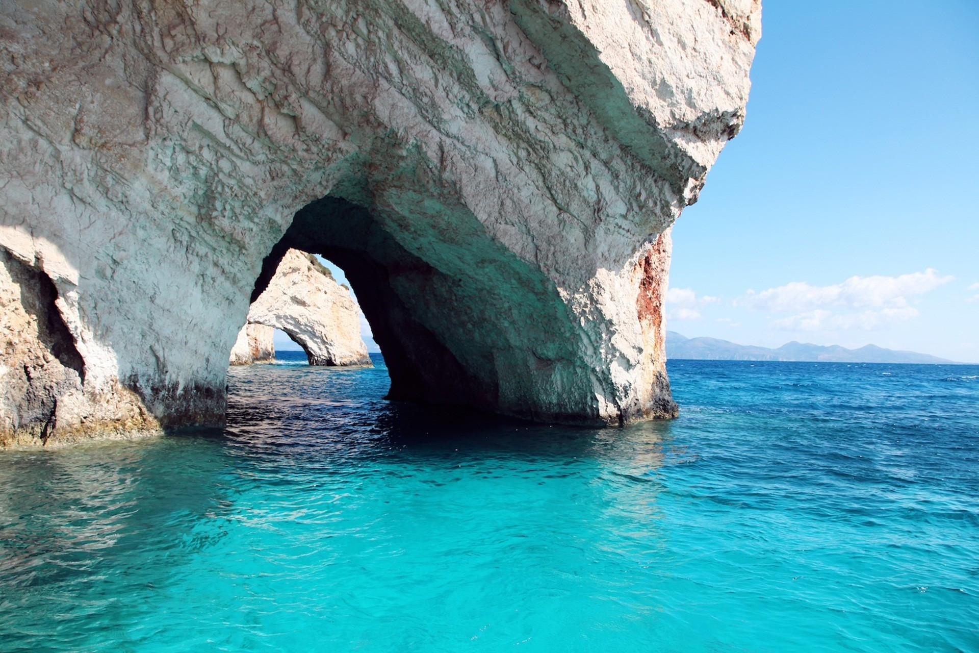 A breathtaking view of the Blue Caves in Zakynthos, Greece, with crystal-clear turquoise water and stunning rock formations