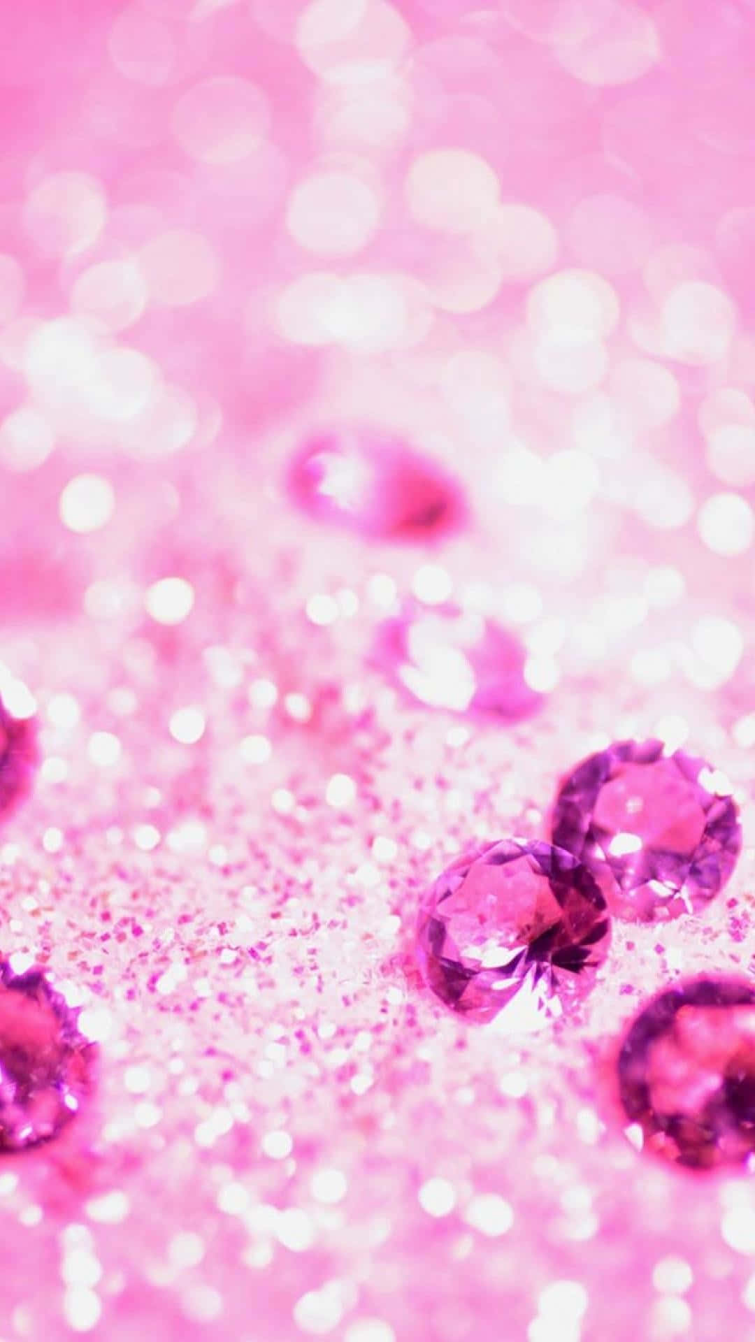 Sparkling pink glitter background with scattered faceted gemstones, creating a luxurious and glamorous aesthetic