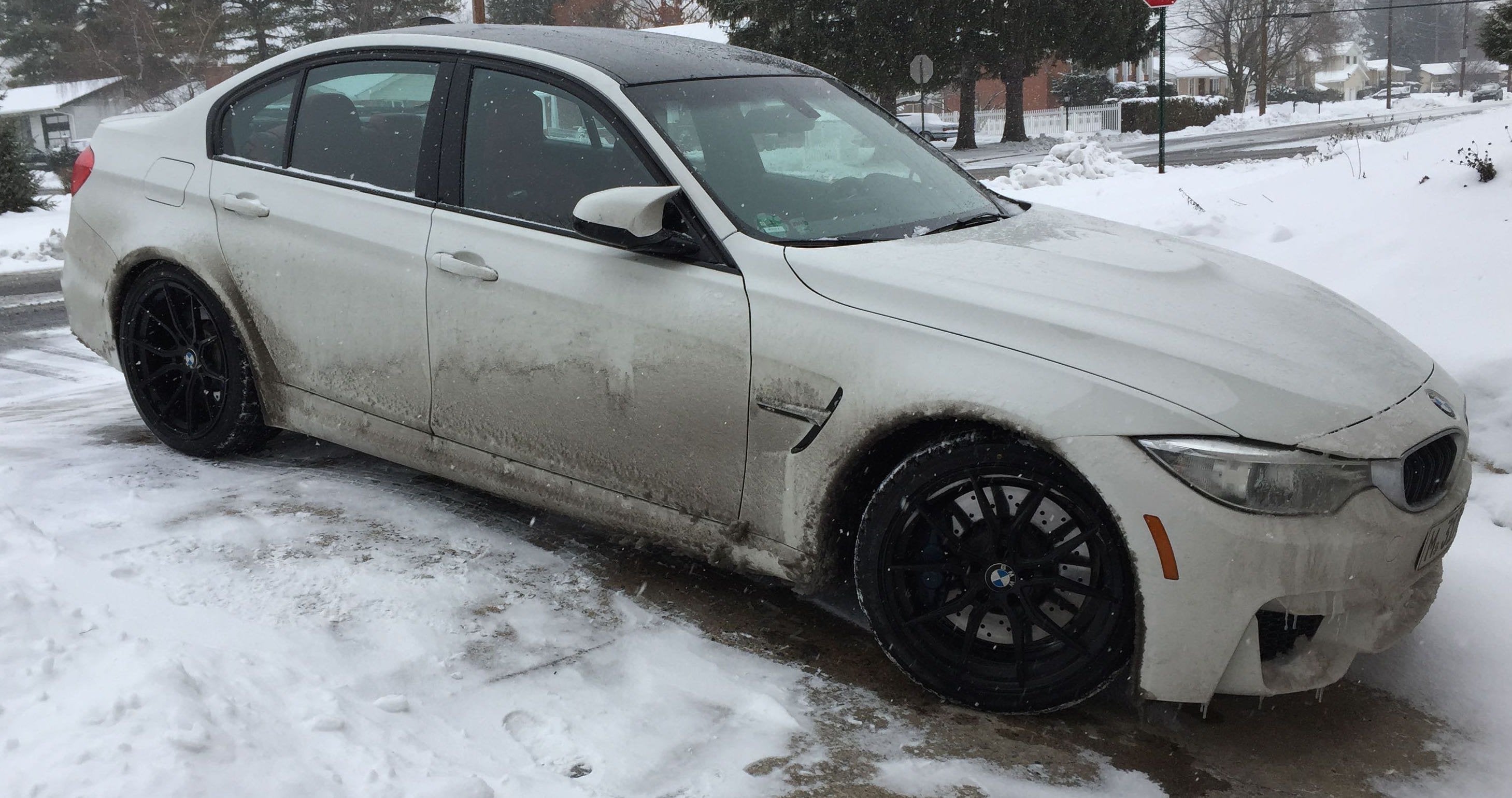White BMW M3 parked in snowy driveway