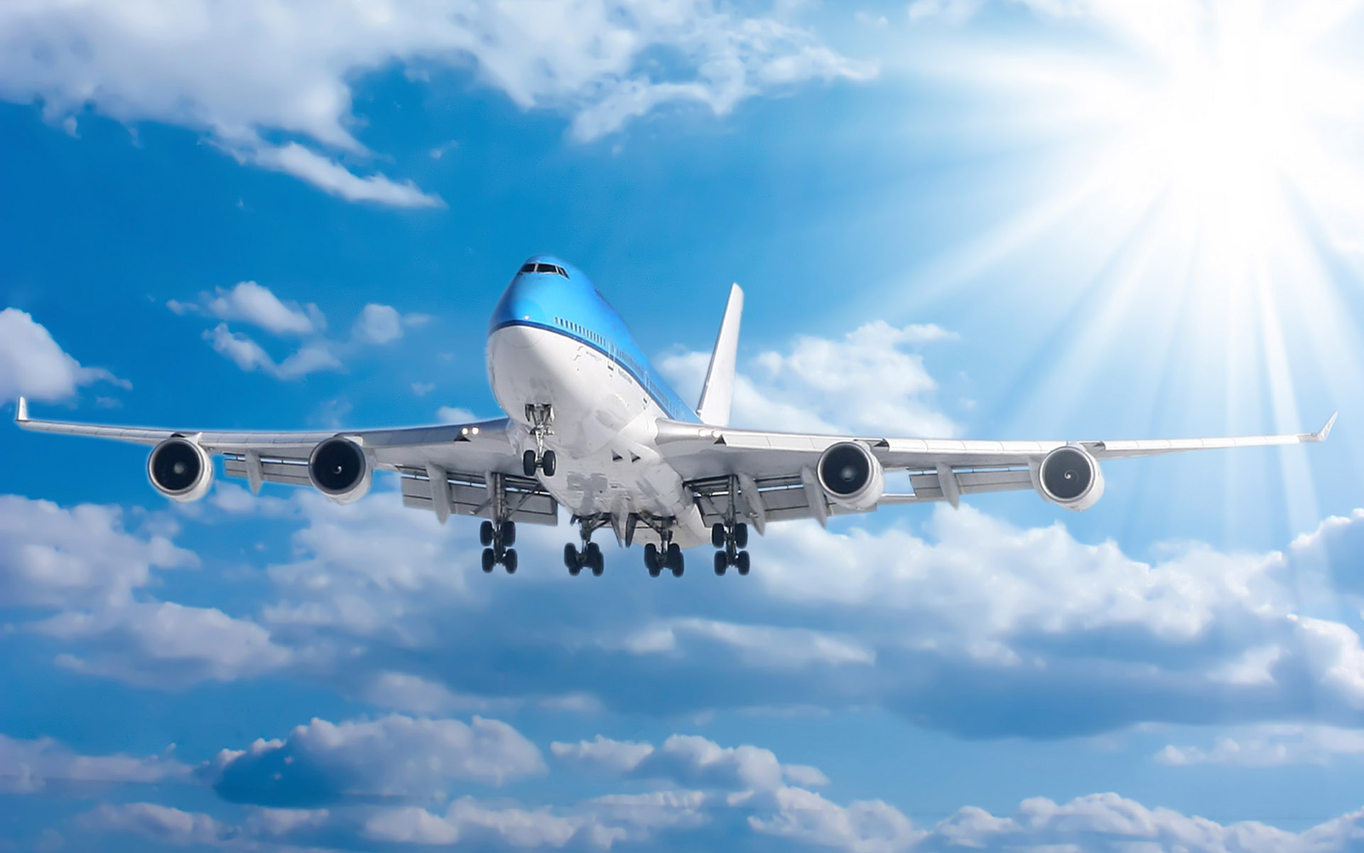 A large passenger airplane flying in a sunny blue sky with fluffy white clouds