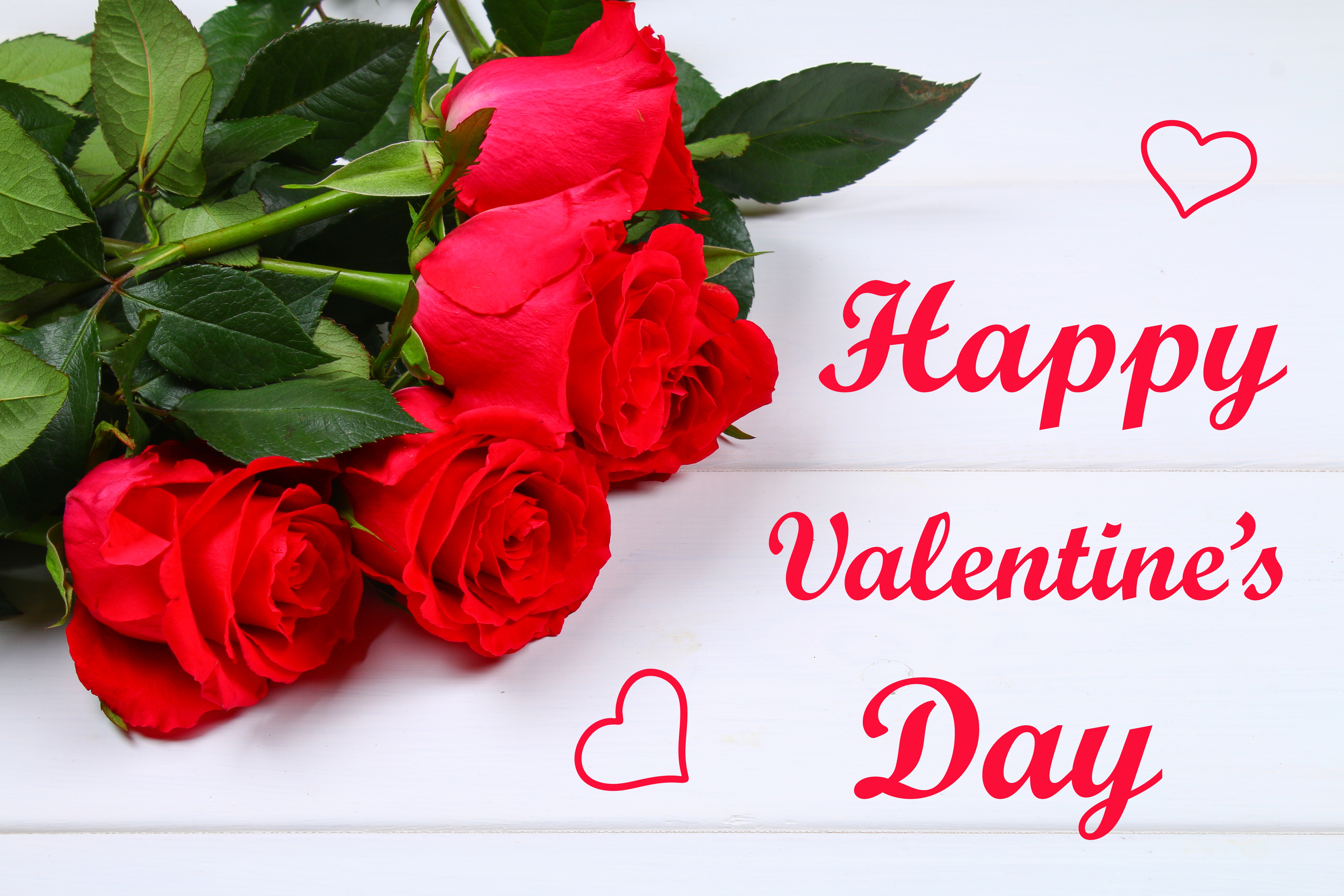 Bouquet of vibrant red roses on a white wooden background with the text 'Happy Valentine's Day'