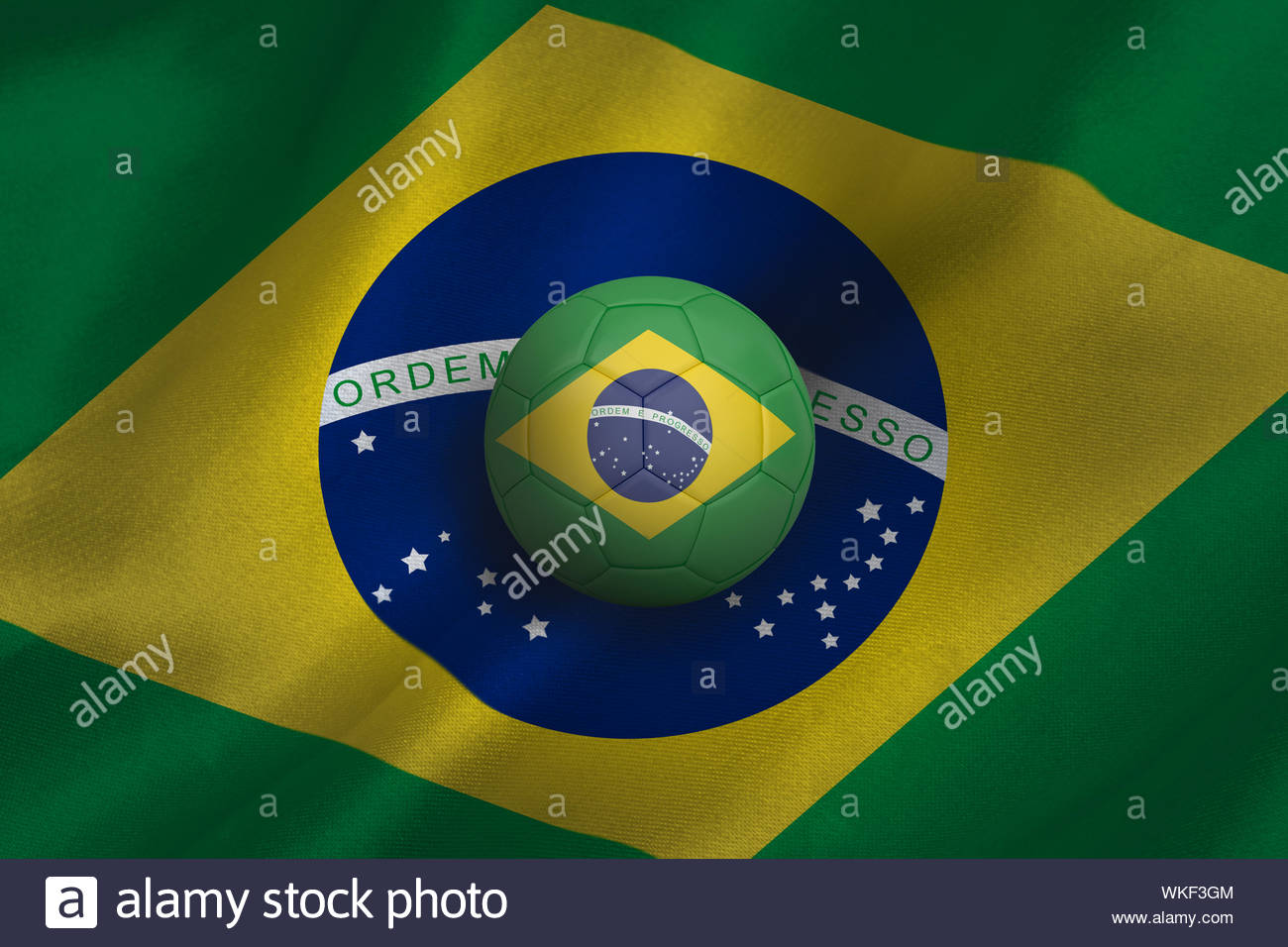 Football In Brasil Colours Against Flag Background Stock Photo