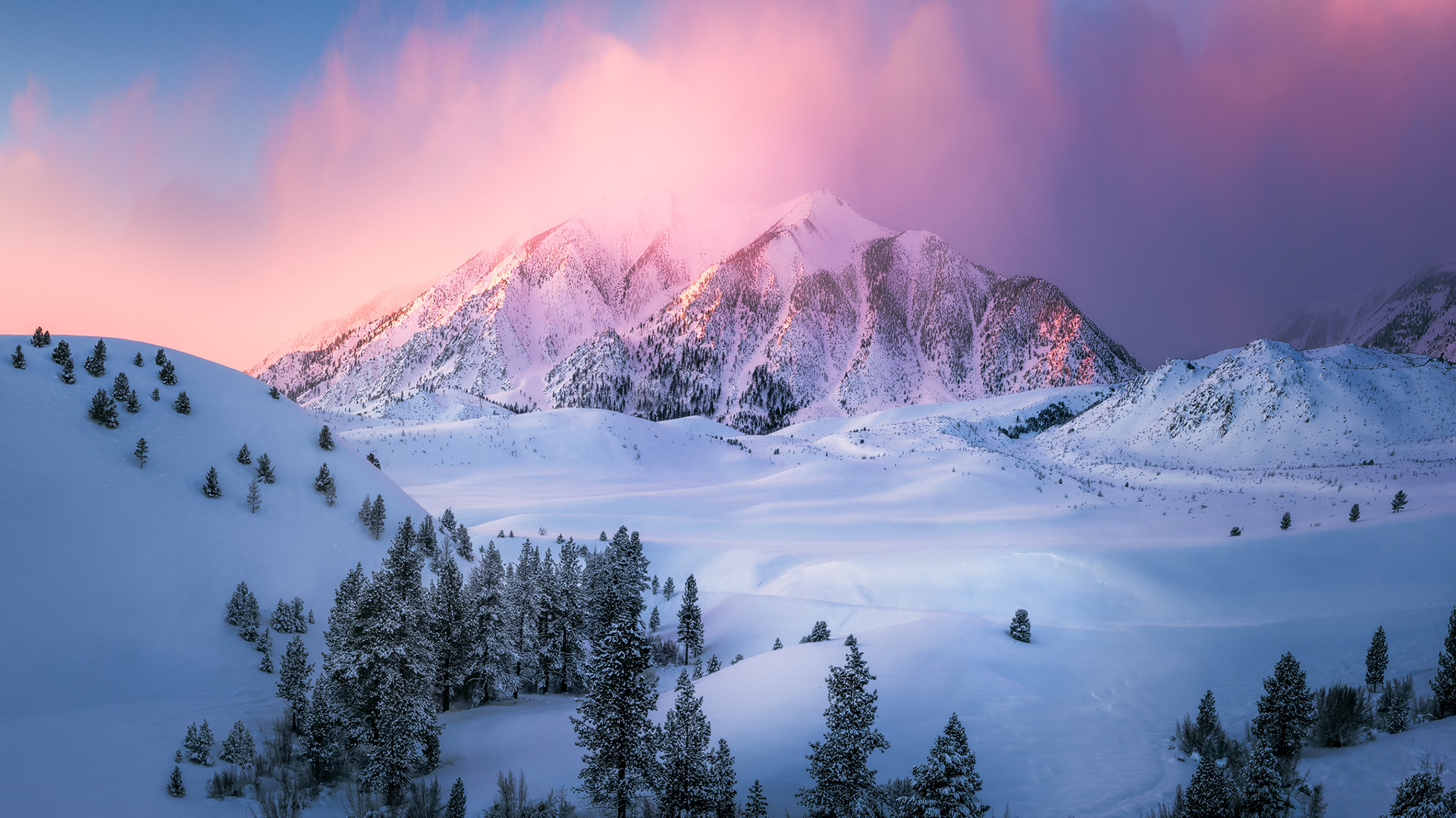 Sunrise over a snow-covered mountain range, winter landscape