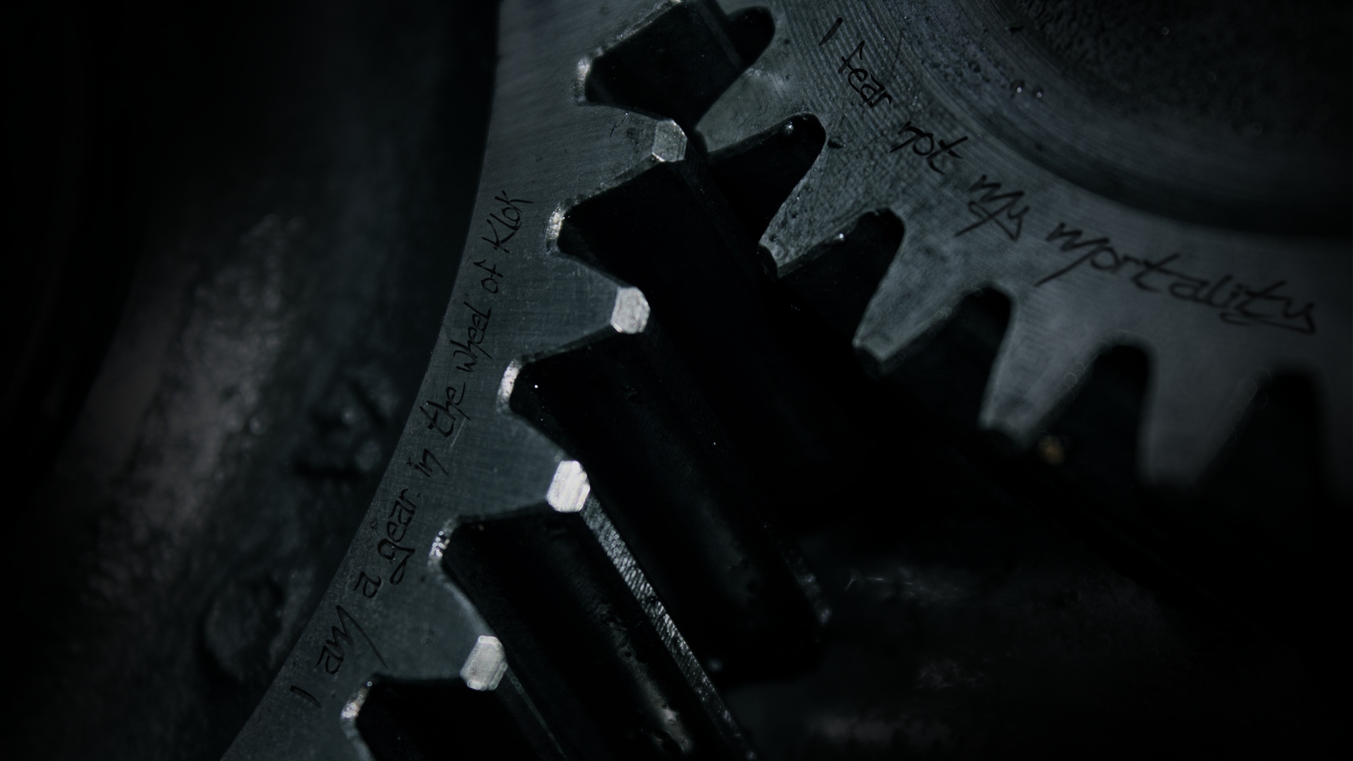 Close-up of a dark metallic gear with inscriptions, evoking themes of time, industry, and mortality
