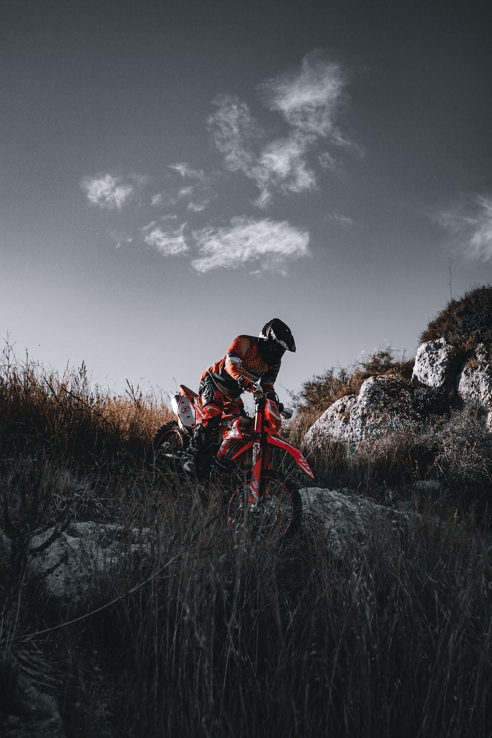 Man In Orange Jacket Riding On Red Dirt Bike Photo Italia