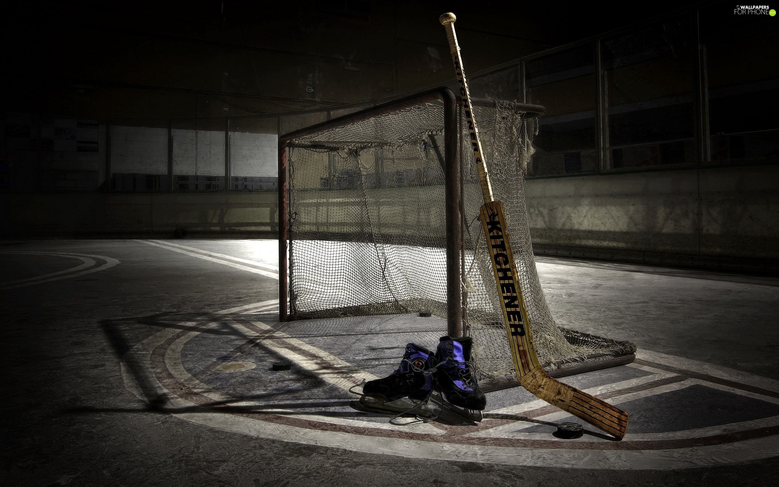 Vintage hockey equipment in an old arena: skates, stick, puck, and net. Evocative of hockey history and the sport's enduring appeal