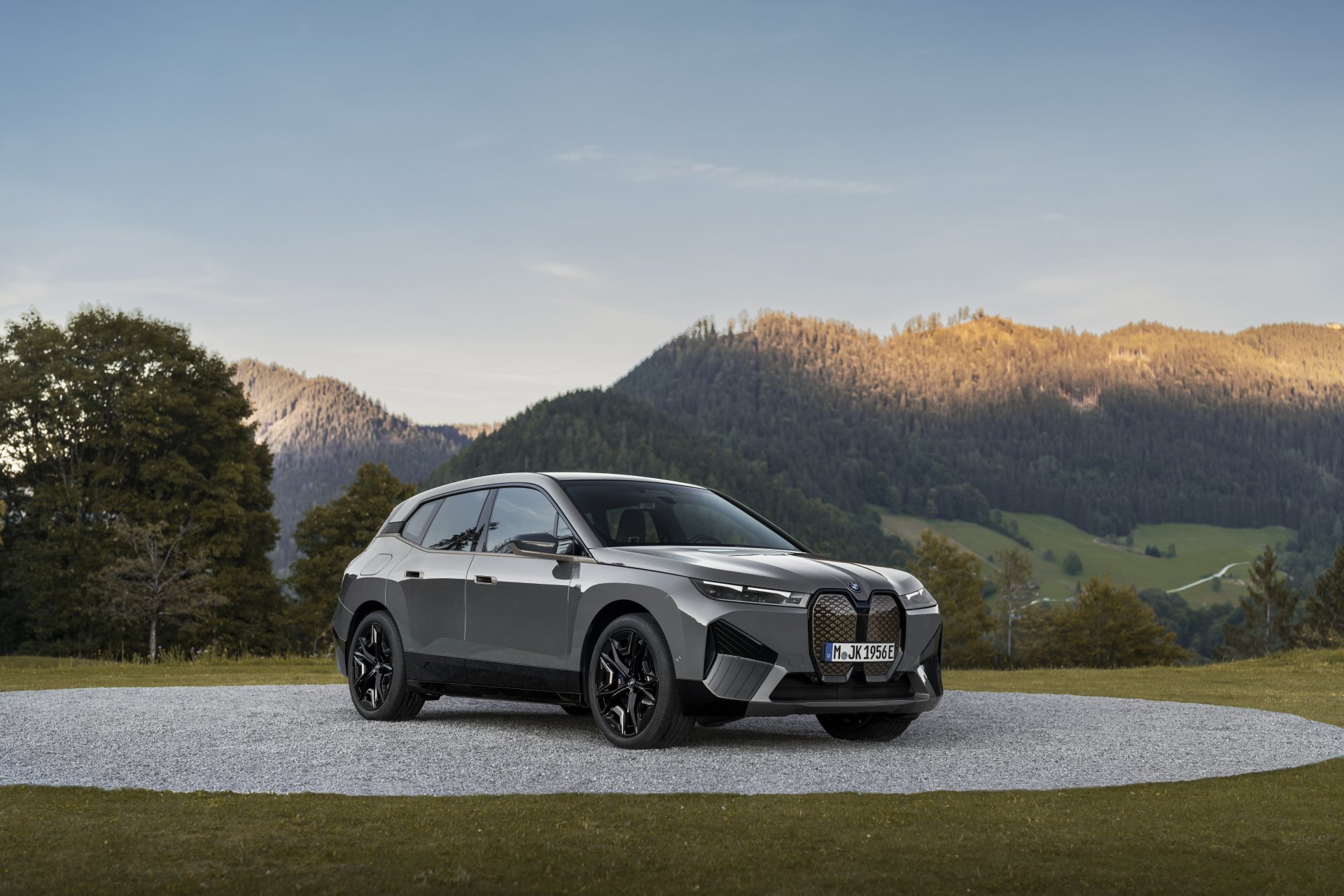 BMW iX Electric SUV parked on a scenic overlook with mountains in the background