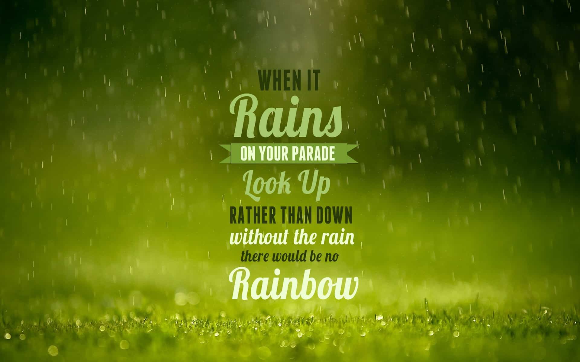 Motivational quote on a rainy background with grass. Text reads: 'When it rains on your parade, look up rather than down. Without the rain, there would be no rainbow.'