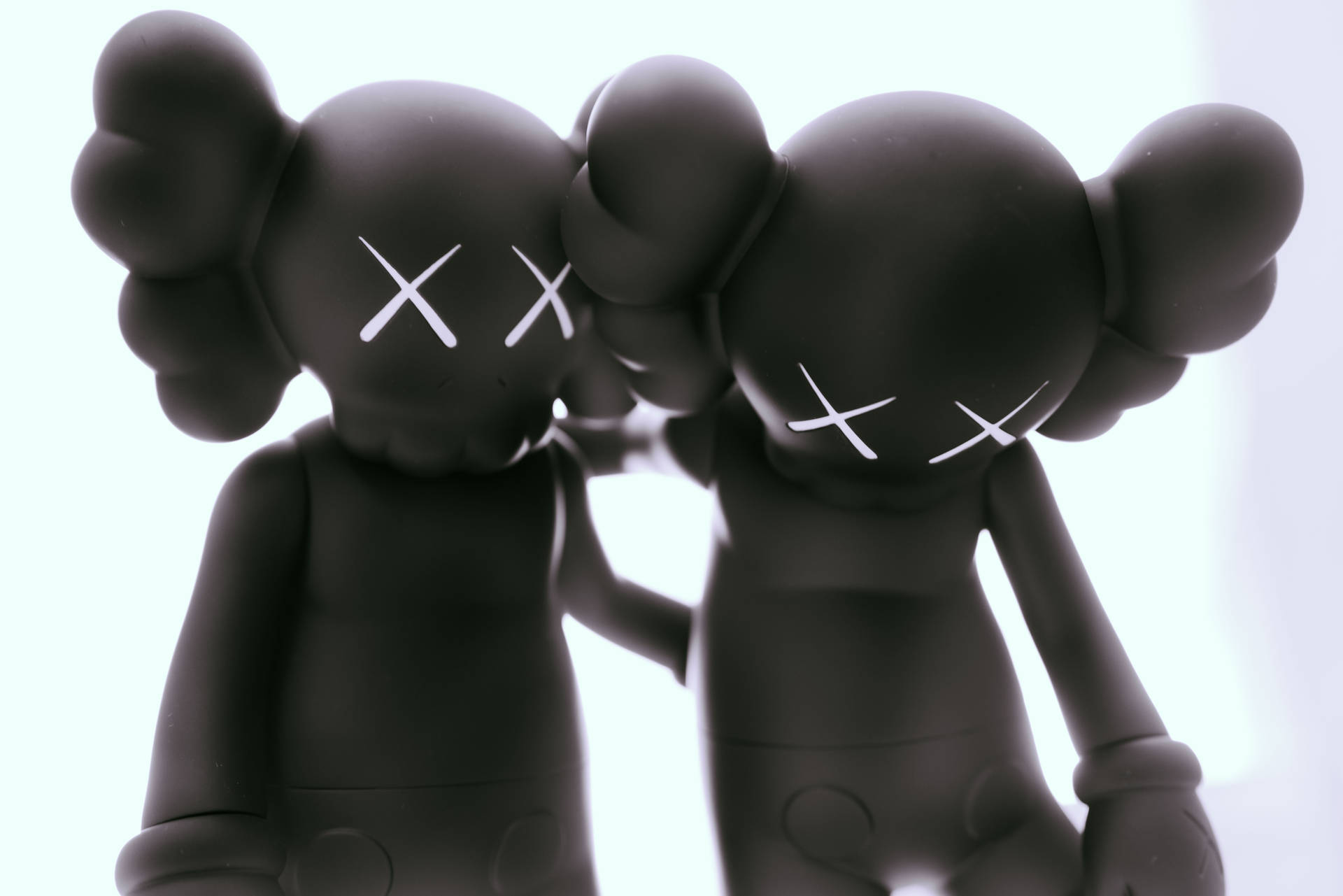 Two black Kaws Companion figures against a white background