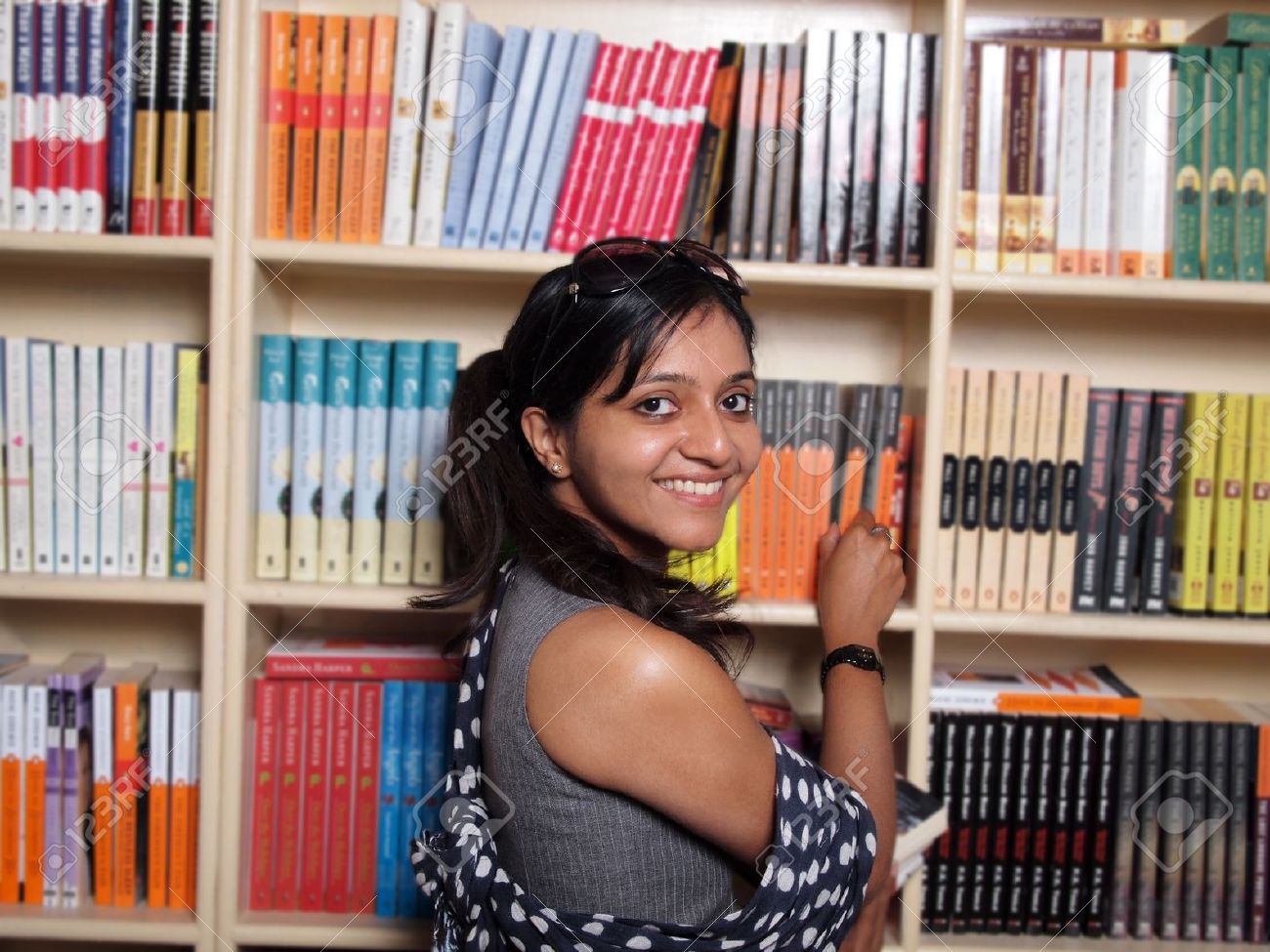 Indian College Student Selecting Books In The Campus Library