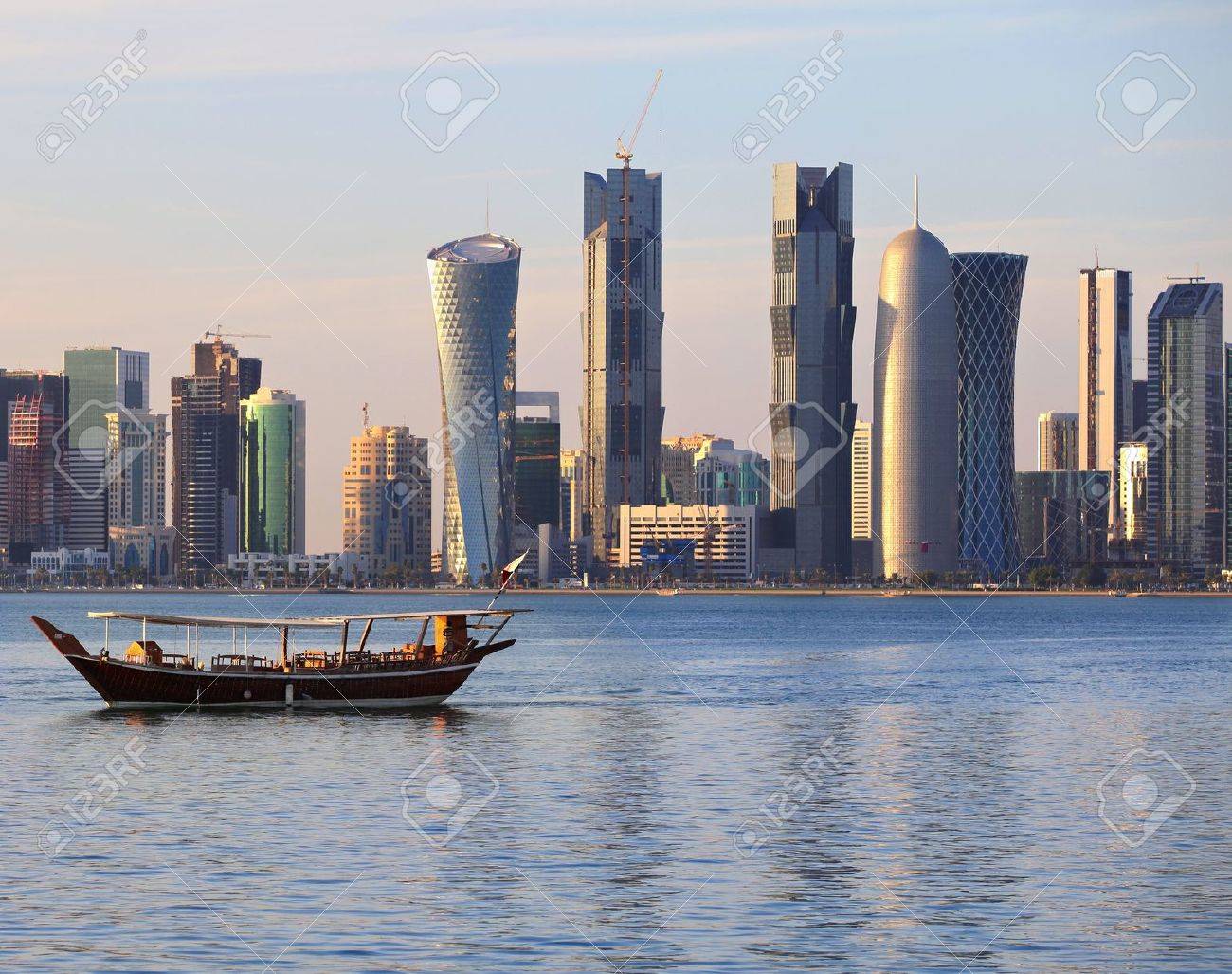 A Dhow Returns To Harbour In Doha Qatar At Sunset With The