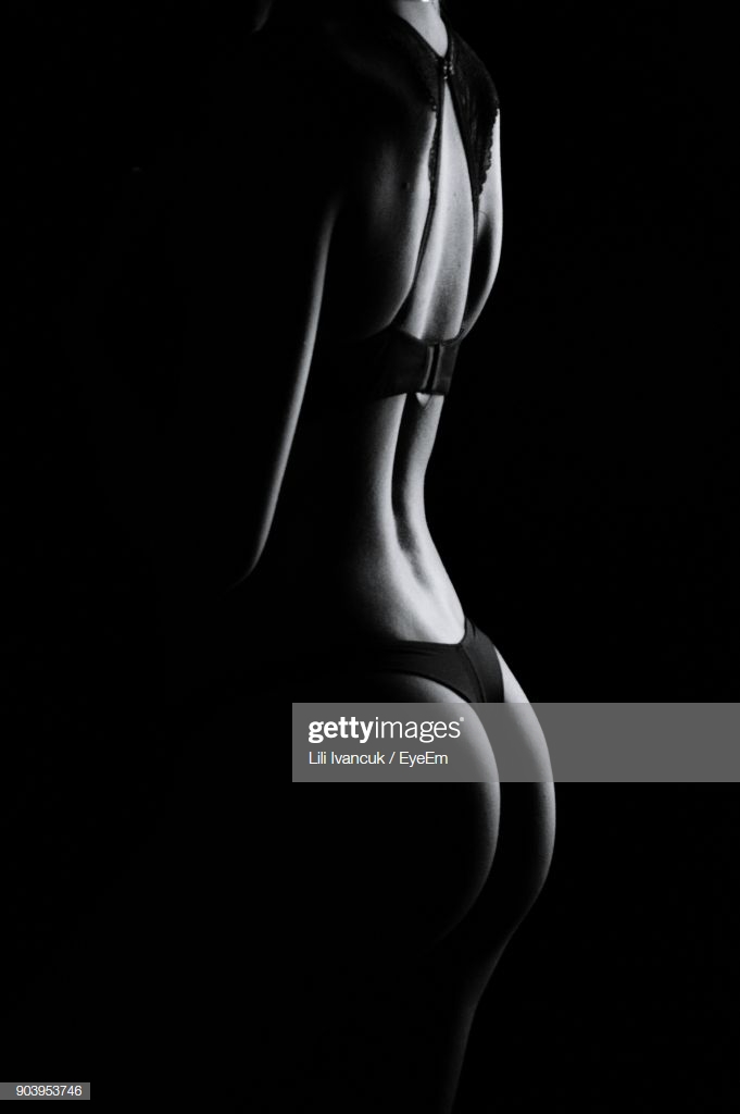 Midsection Of Seductive Woman Standing Against Black Background