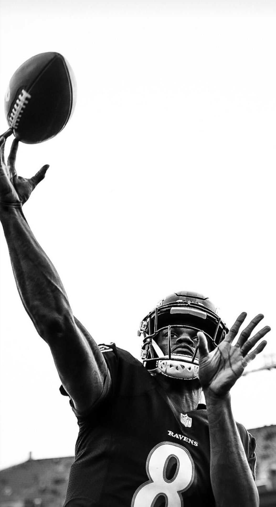 Black and white action shot of Justin Jackson, Baltimore Ravens running back, catching a football