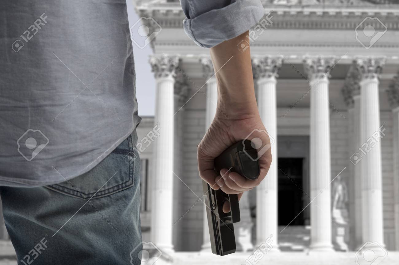 Security Man Holding Gun Against An Courthouse Background Stock