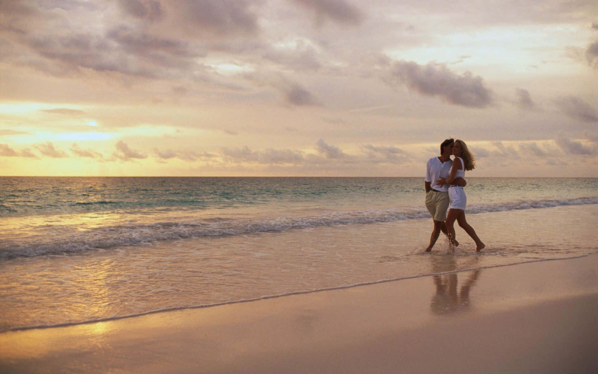 Couple At Beach Walking On Waves During Sunset Picture Wallpaper