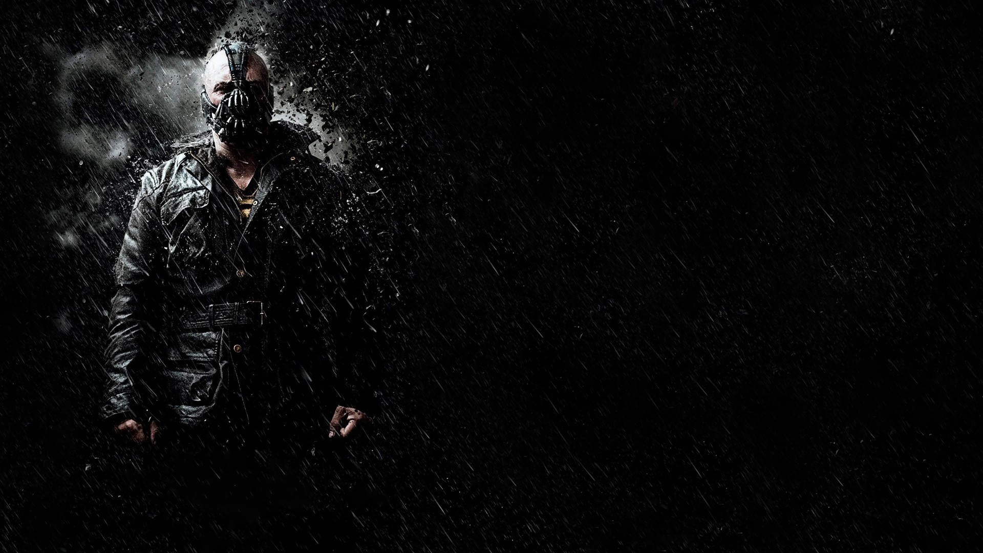A dark and brooding figure, reminiscent of Bane from The Dark Knight Rises, stands in the pouring rain. The ominous atmosphere and dramatic lighting create a cool, cinematic wallpaper