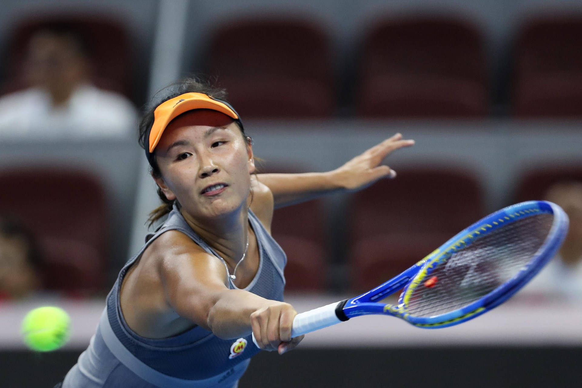 Shuai Peng Powerfully Reaching For A Tennis Ball In Match Wallpaper