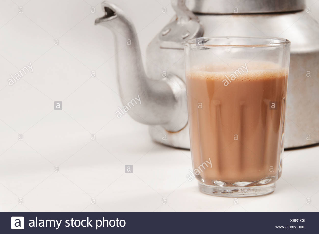 Glass Of Chai With An Old Fashioned Kettle Isolated Over White