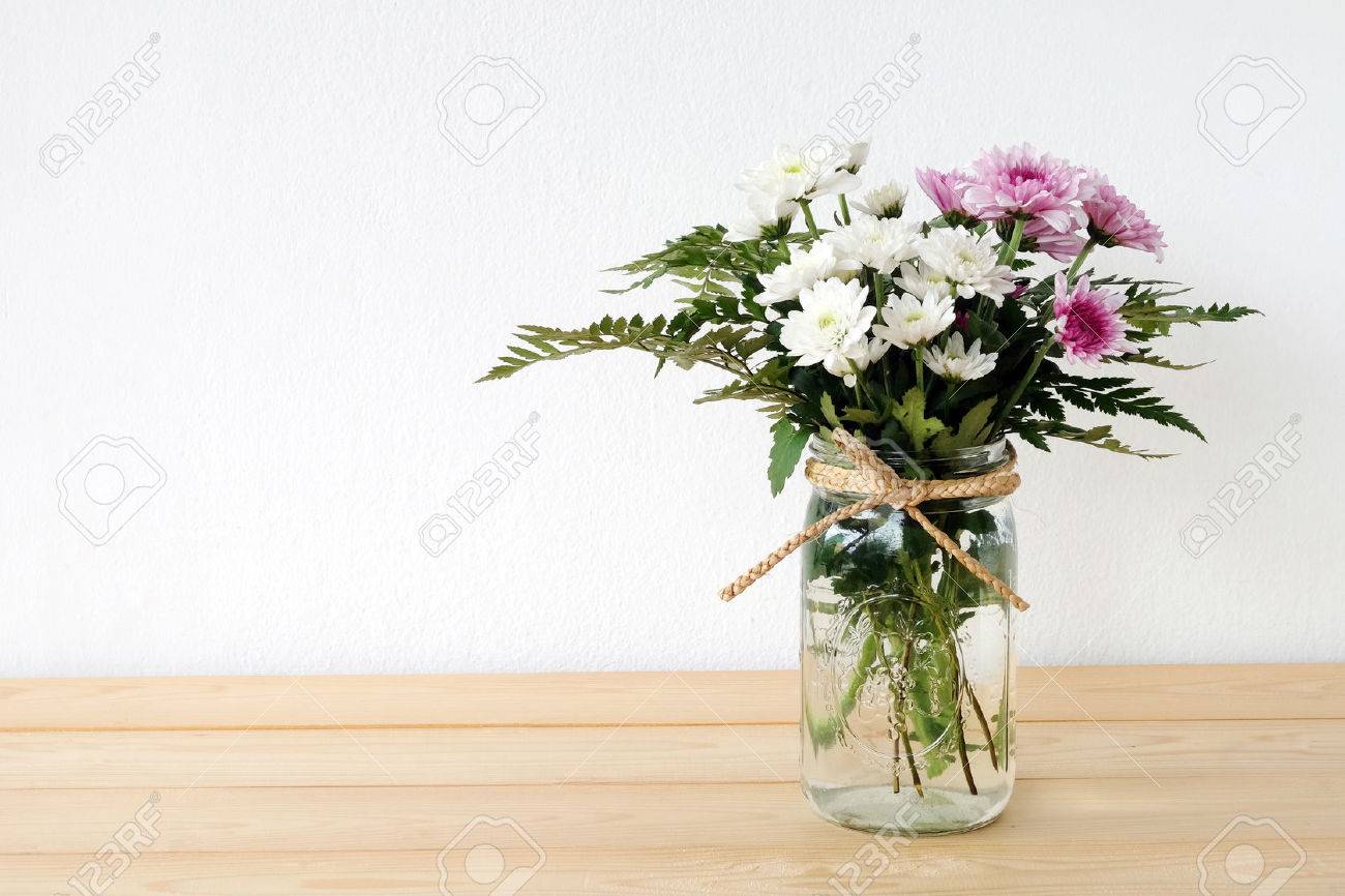 White And Pink Daisy Bouquet In Mason Jar On Table Background
