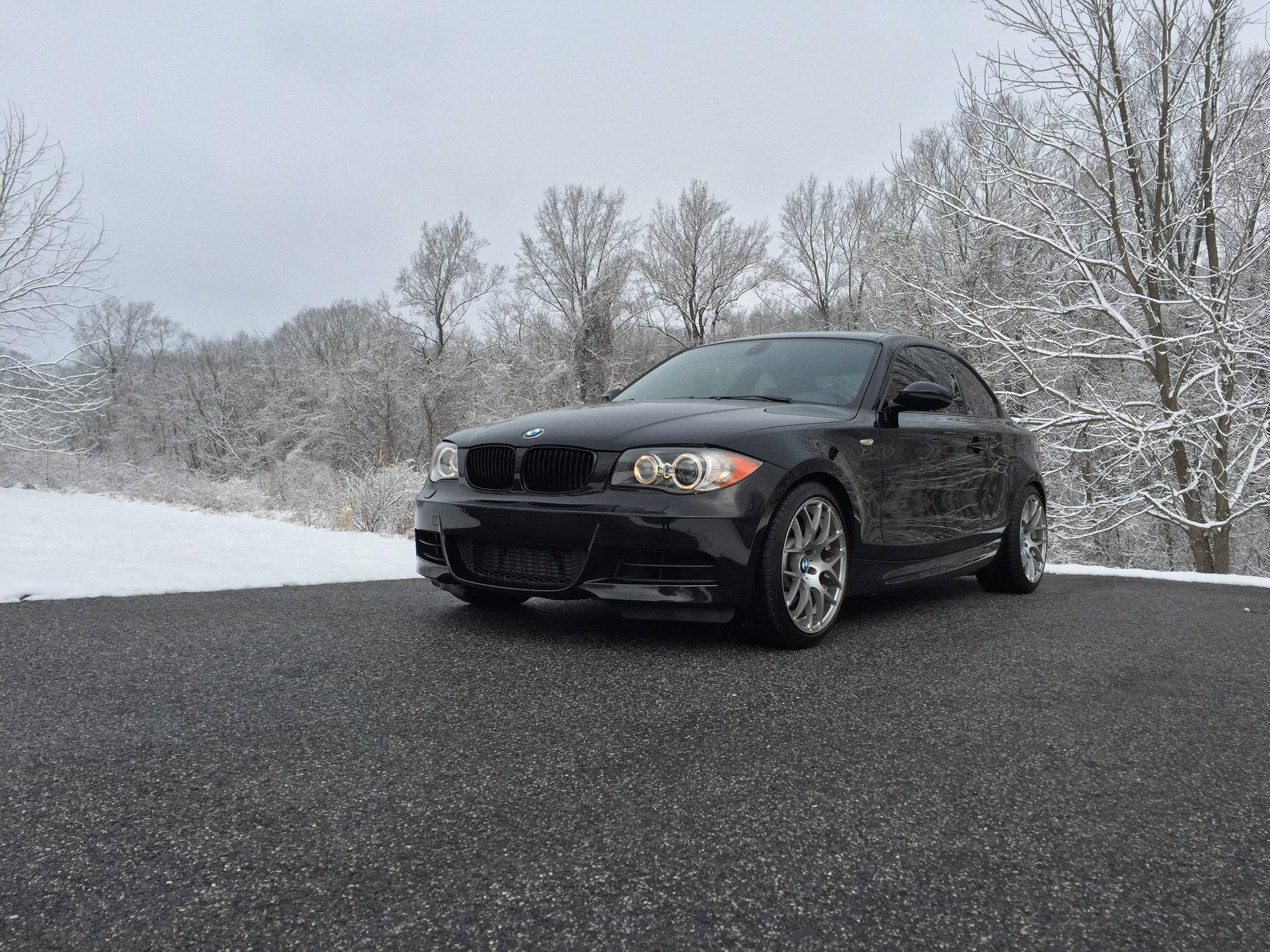 Black BMW 1 Series Coupe parked on a snowy driveway