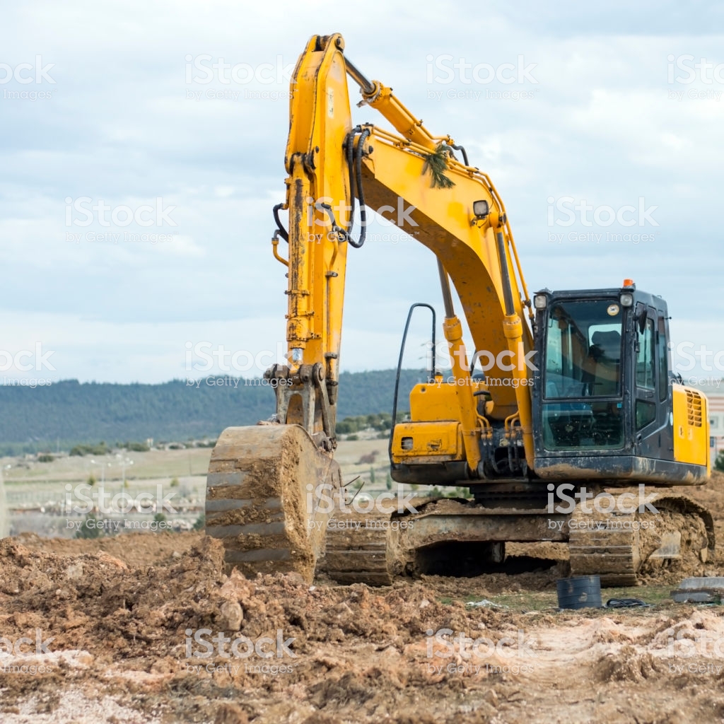 Yellow Excavator At Construction Site Into Mud With Sky Background