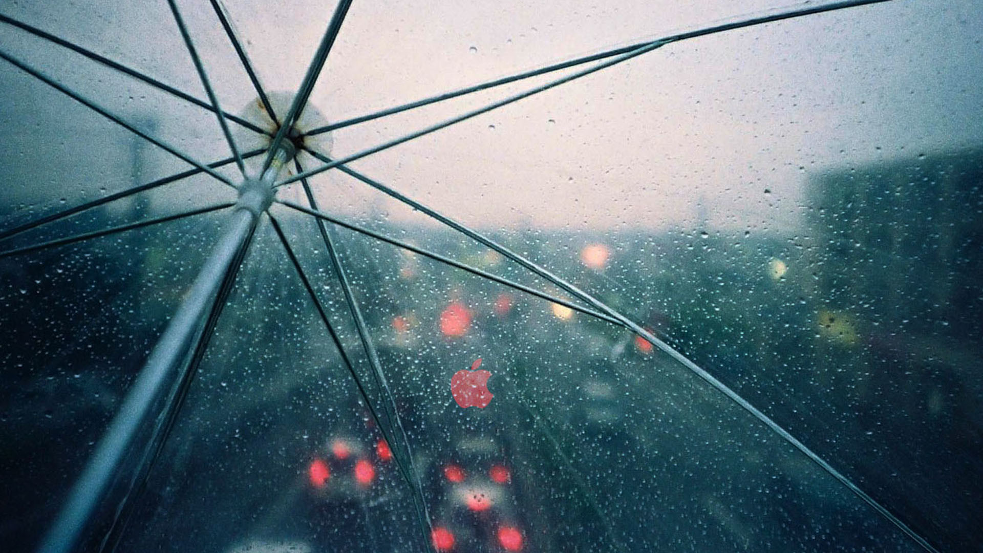 Close-up of a transparent umbrella with raindrops on it, blurred city traffic in the background on a rainy day
