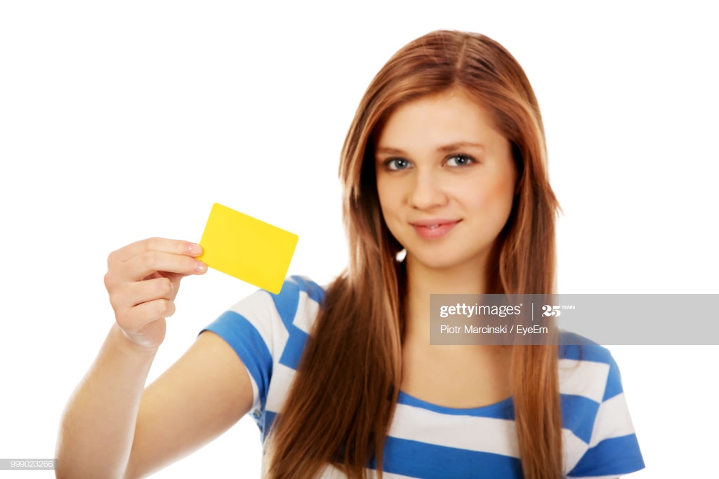 Portrait Of Young Woman Holding Yellow Card Against White
