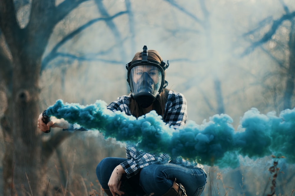 Person Wearing Black Gas Mask While Using Blue Smoke Photo