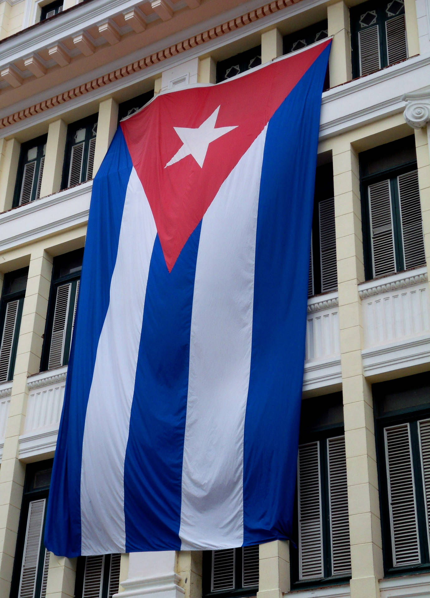 The Authentic Cuban Flag Waving In Front Of A Classical Wallpaper