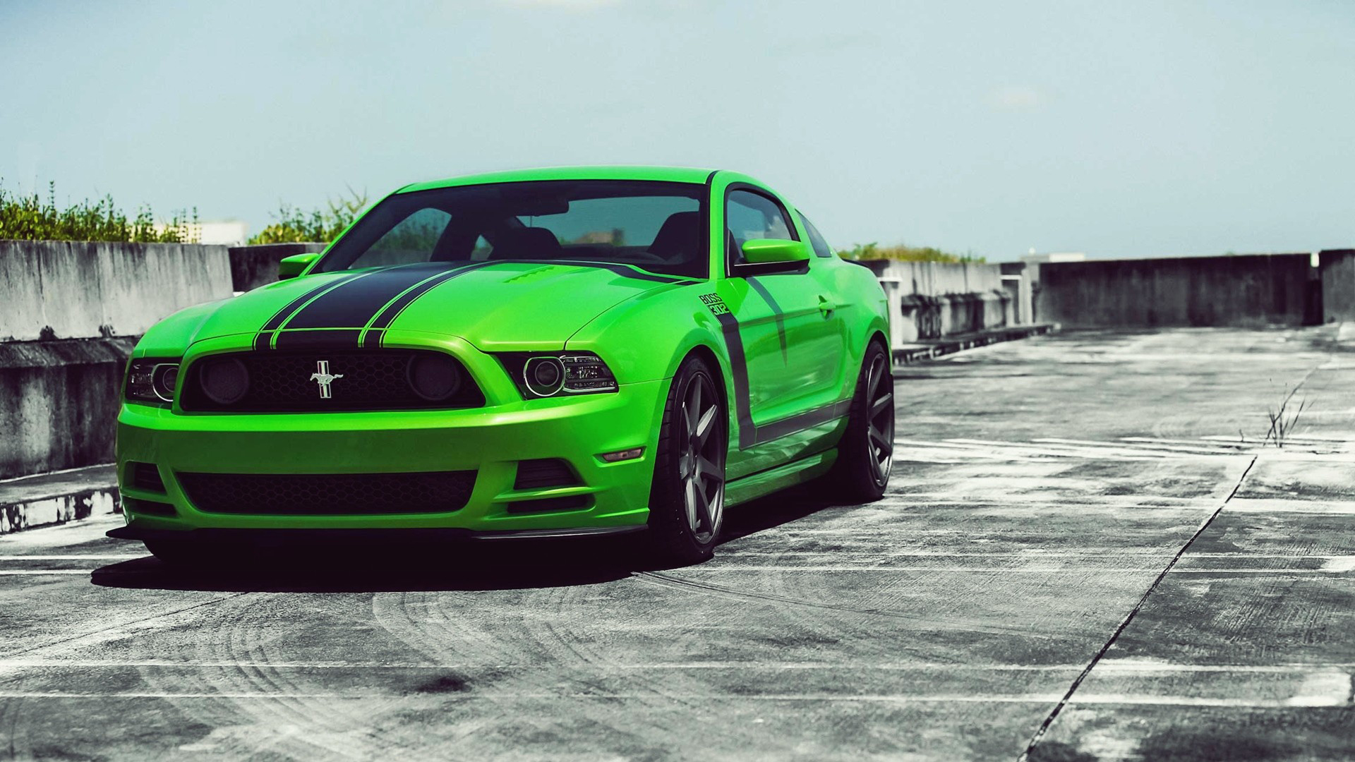Bright Green Ford Mustang with Black Racing Stripes Parked on Rooftop