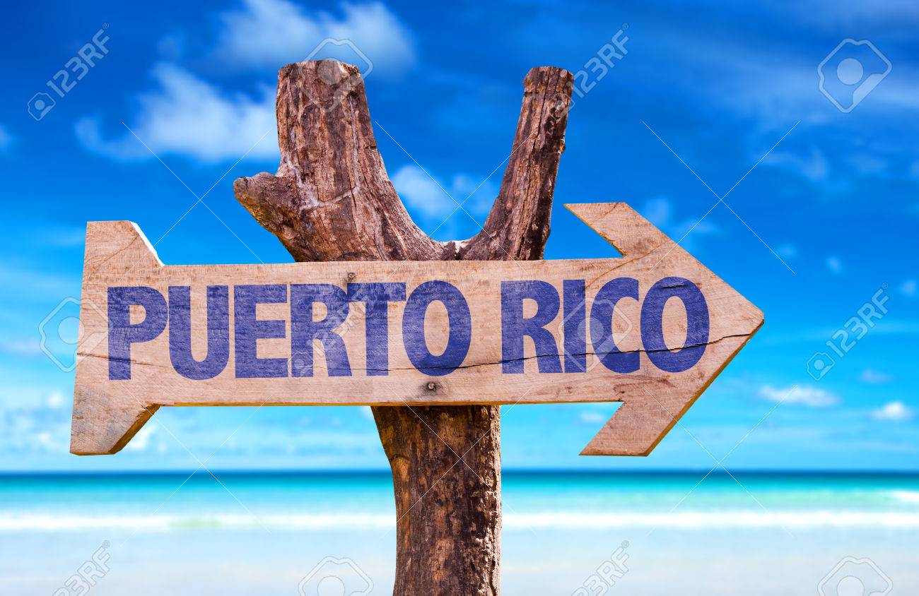Puerto Rico Sign With Arrow On Beach Background Stock Photo