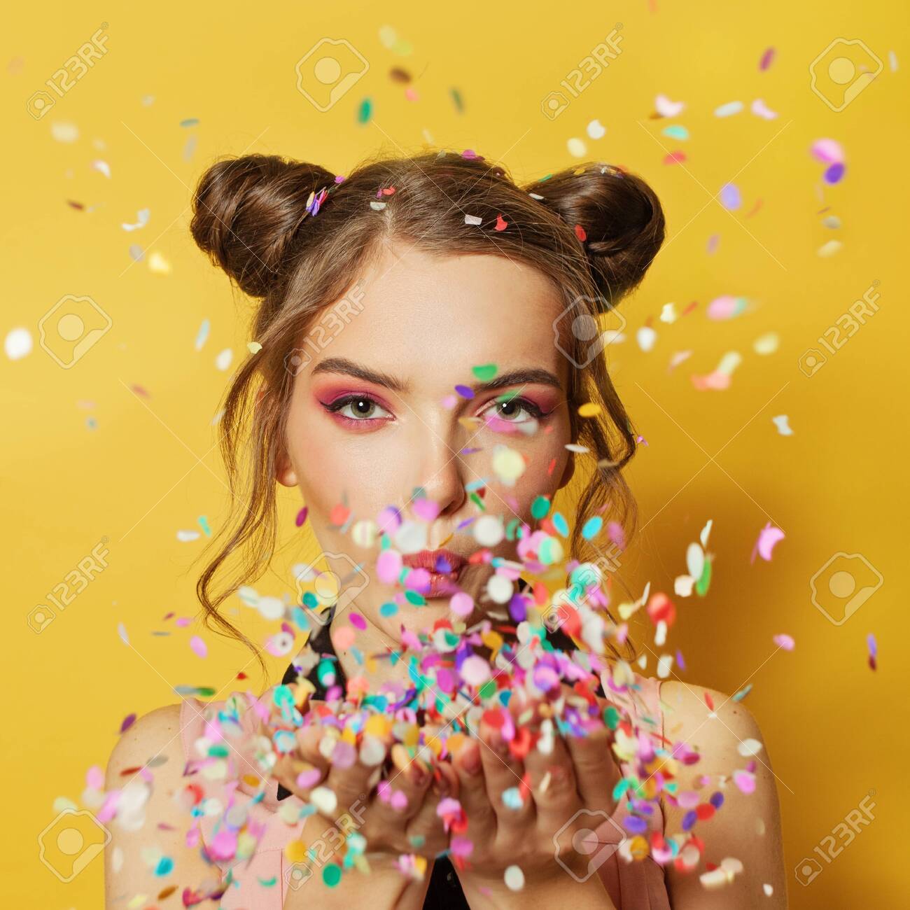 Happy Beautiful Woman Blowing Colorful Confetti On Yellow Card