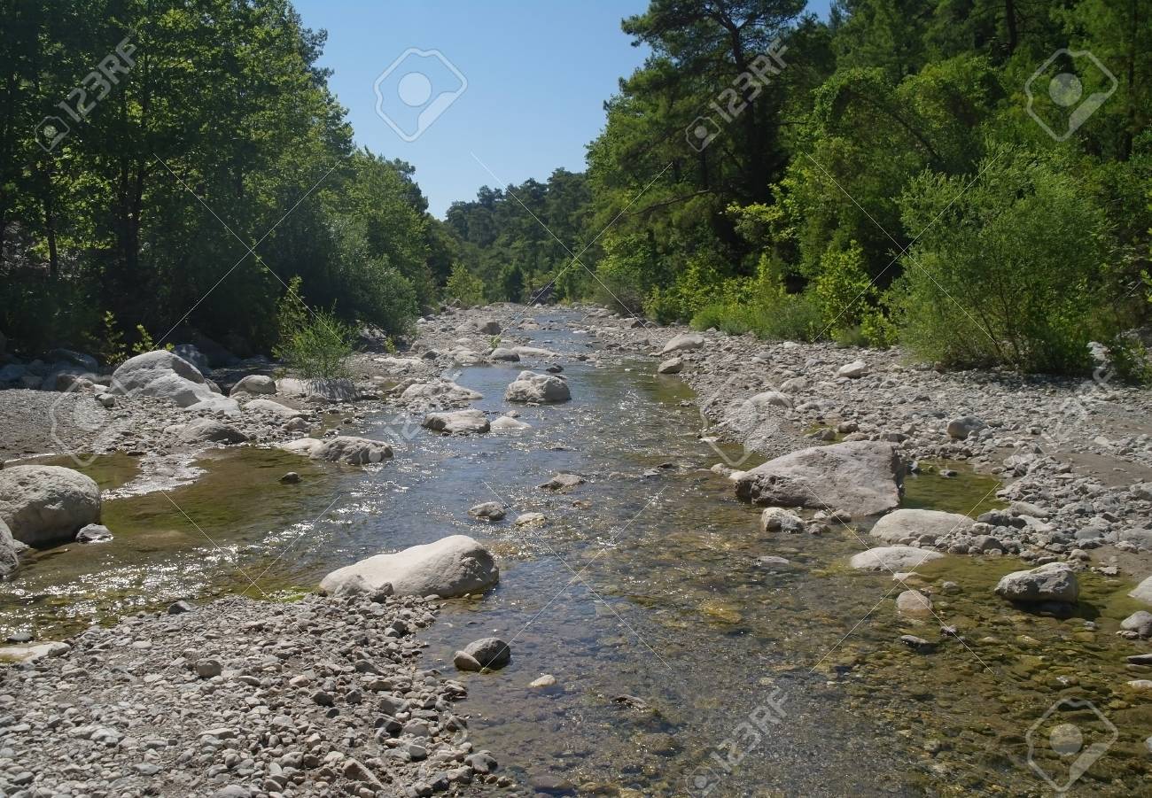 Rocks On Riverbank With River In Background Stock Photo Picture