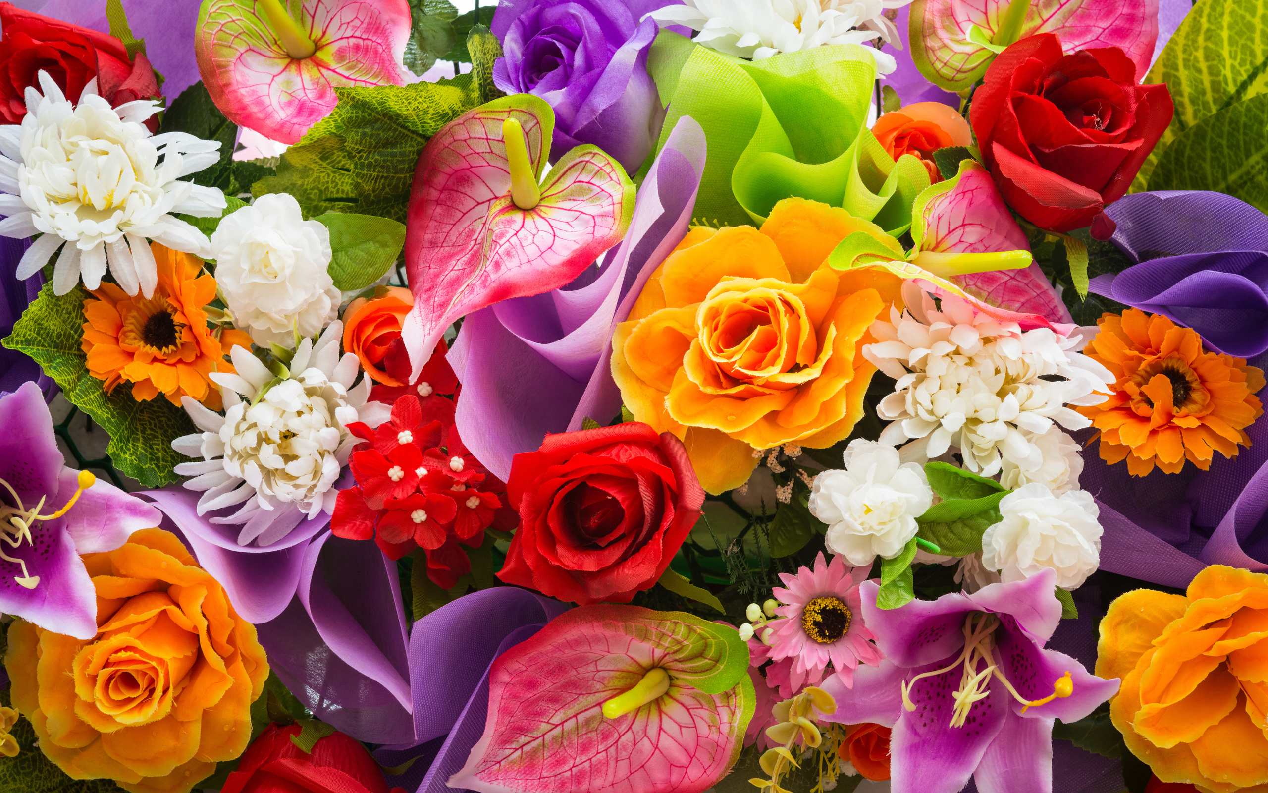 A vibrant and colorful close-up of various artificial flowers, showcasing a mix of roses, lilies, anthuriums, chrysanthemums, and other blossoms in a full arrangement